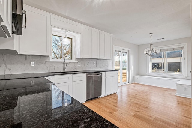 kitchen with pendant lighting, sink, white cabinets, dark stone counters, and stainless steel dishwasher