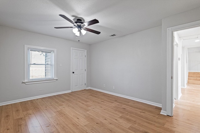 empty room featuring ceiling fan, a textured ceiling, and light hardwood / wood-style floors