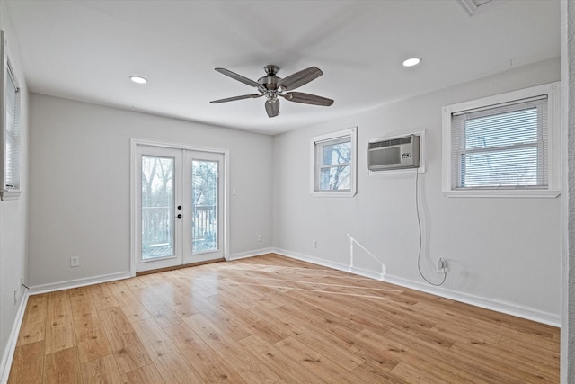 spare room featuring french doors, ceiling fan, a wall mounted AC, and light hardwood / wood-style flooring