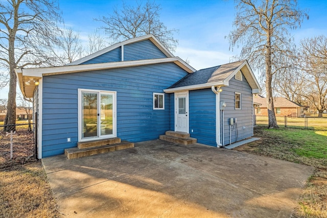 back of property with a lawn and a patio area