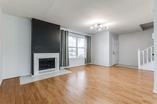 unfurnished living room with light hardwood / wood-style floors and an inviting chandelier