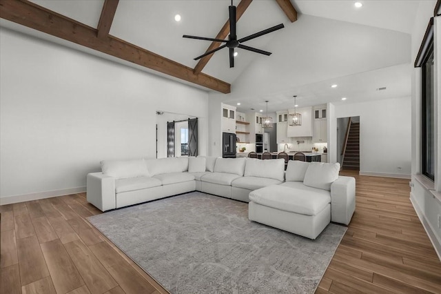 living room featuring beam ceiling, ceiling fan, and high vaulted ceiling