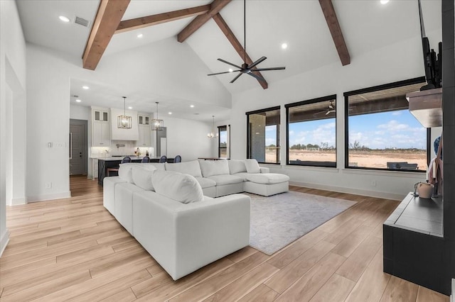 living room featuring ceiling fan, beamed ceiling, and high vaulted ceiling