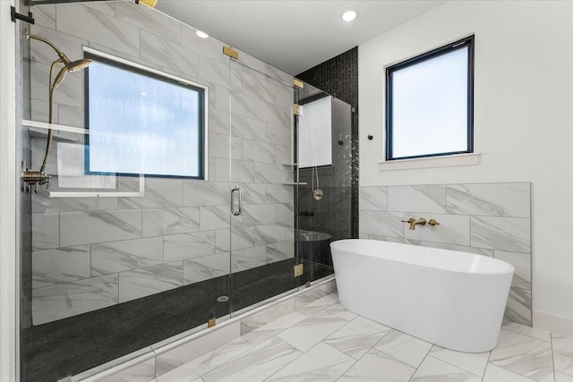 bathroom featuring independent shower and bath and tile walls