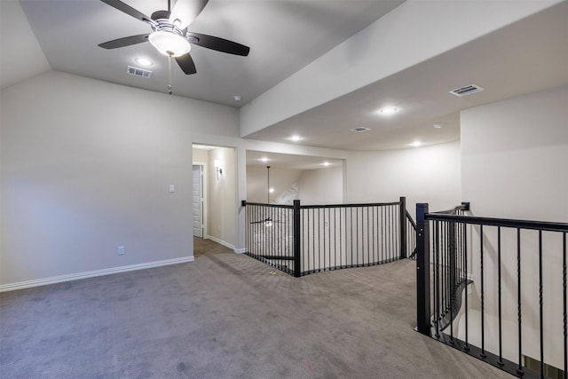 carpeted empty room with ceiling fan and vaulted ceiling