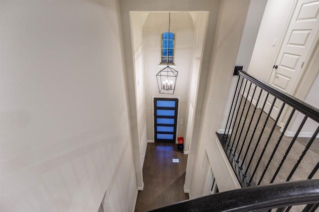 staircase featuring a chandelier and hardwood / wood-style flooring