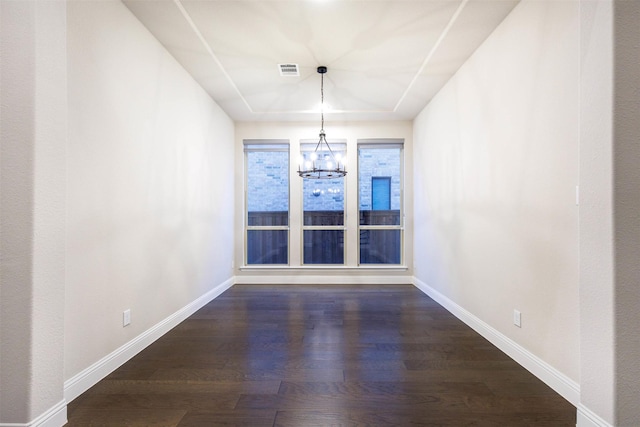 unfurnished dining area featuring a chandelier and dark hardwood / wood-style floors