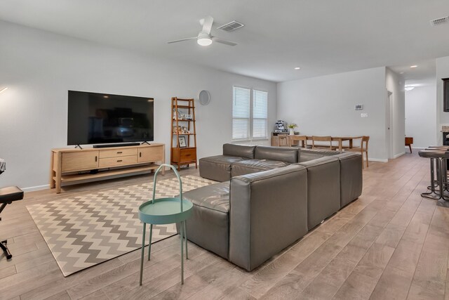 living room with ceiling fan and hardwood / wood-style floors