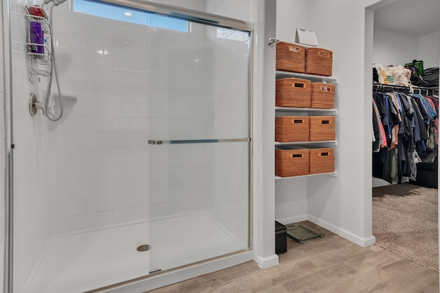 bathroom featuring wood-type flooring and a shower with door