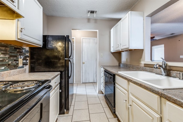 kitchen featuring sink, white cabinets, backsplash, light tile patterned flooring, and black appliances