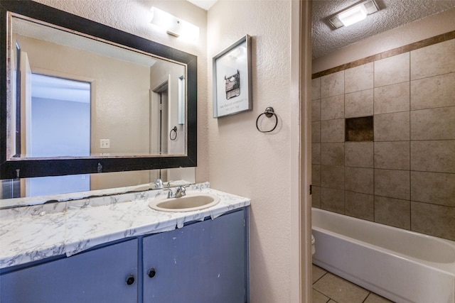 bathroom with tile patterned flooring, vanity, a textured ceiling, and tiled shower / bath combo