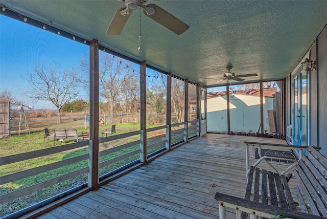 unfurnished sunroom featuring ceiling fan