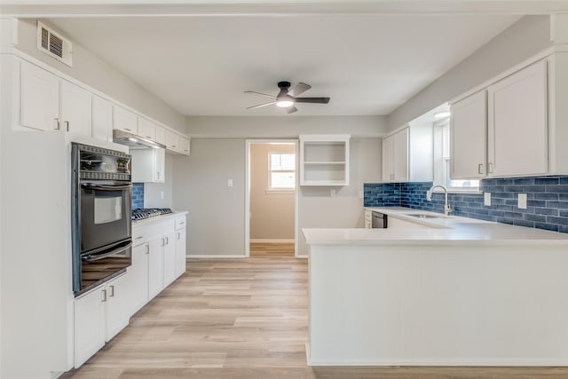 kitchen featuring a sink, visible vents, light countertops, decorative backsplash, and a warming drawer