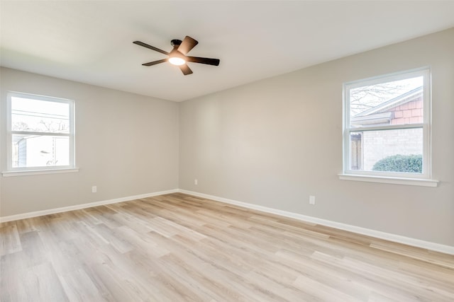 spare room with light wood-type flooring, plenty of natural light, and ceiling fan