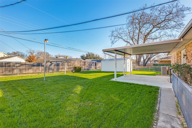 view of yard featuring cooling unit, a patio area, and a storage shed