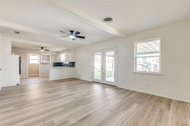 unfurnished living room featuring ceiling fan, beam ceiling, light hardwood / wood-style flooring, and french doors