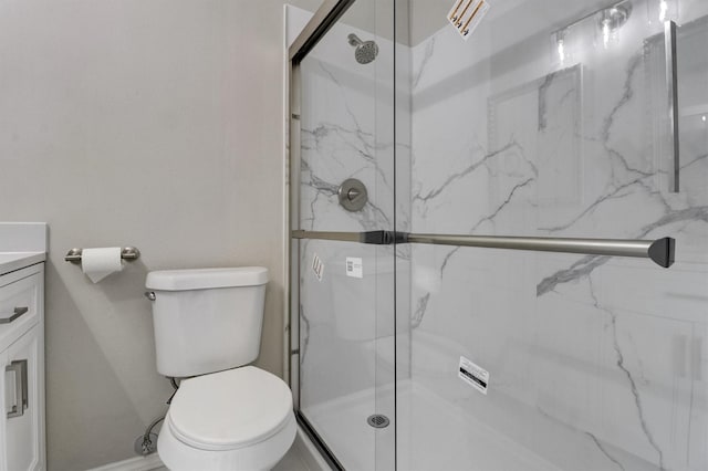 bathroom with an enclosed shower, vanity, and toilet