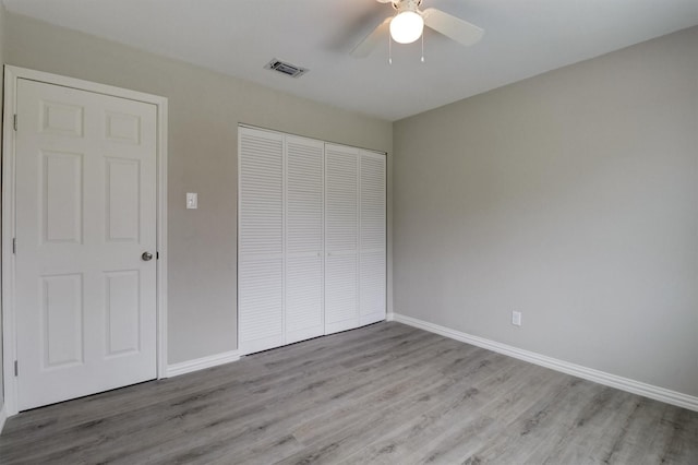 unfurnished bedroom with ceiling fan, light hardwood / wood-style floors, and a closet