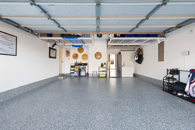 garage with a garage door opener, electric panel, and stainless steel fridge