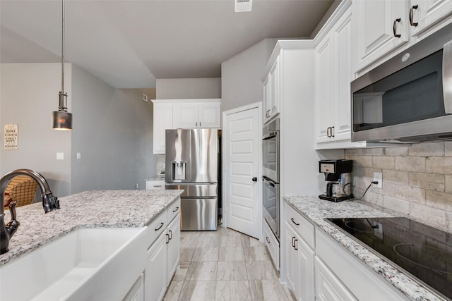 kitchen featuring sink, pendant lighting, stainless steel appliances, and white cabinetry