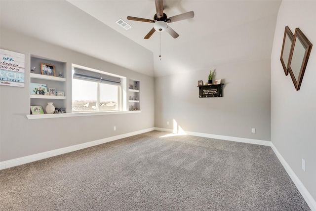 carpeted empty room with vaulted ceiling, ceiling fan, and built in features