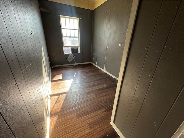 unfurnished room with wood walls, cooling unit, and hardwood / wood-style floors