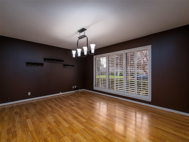 unfurnished dining area with hardwood / wood-style floors and a notable chandelier