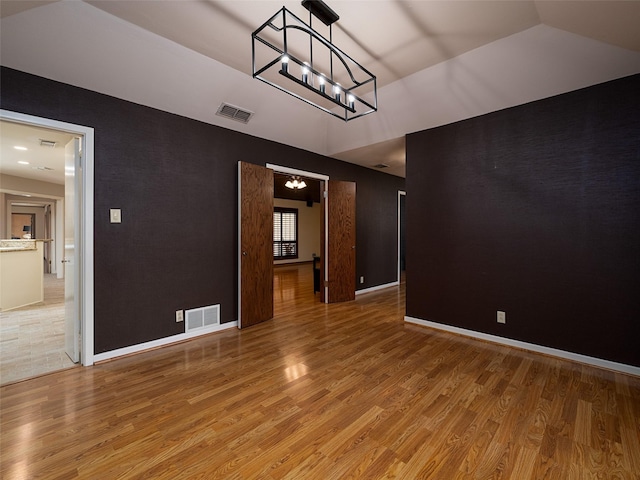 interior space with hardwood / wood-style floors, lofted ceiling, and a chandelier