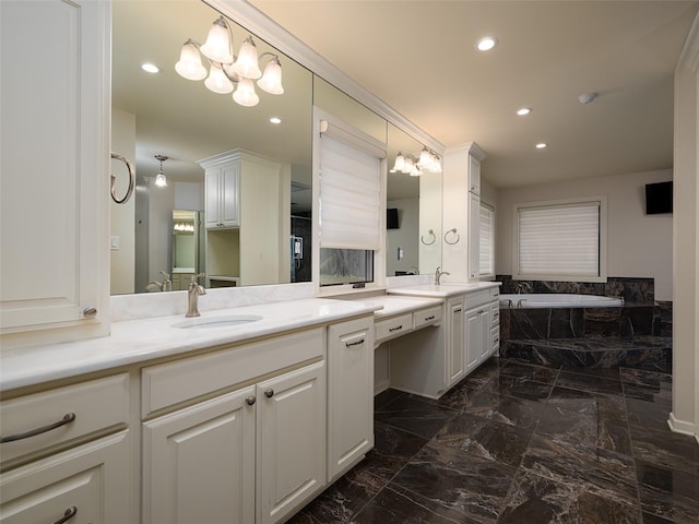 bathroom with a bathing tub, vanity, and a notable chandelier