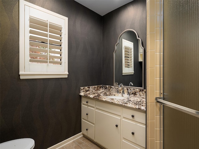 bathroom with vanity, toilet, and a shower with shower door