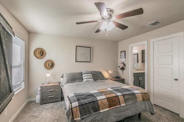 carpeted bedroom with ceiling fan and ensuite bathroom