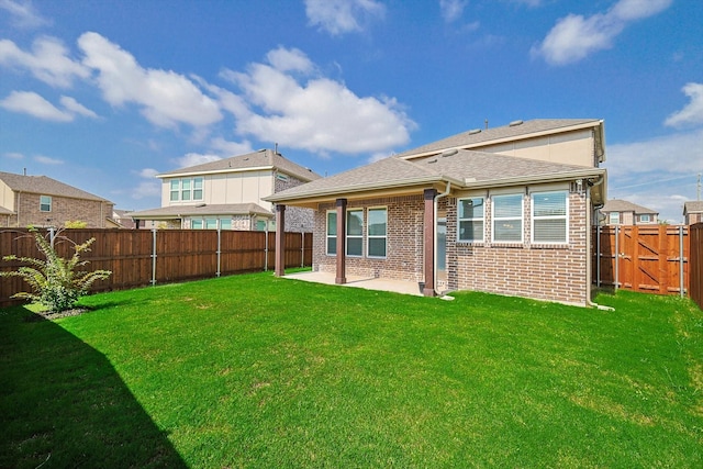 back of property with a patio area and a lawn