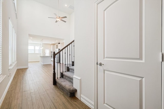 entrance foyer featuring ceiling fan, light wood-type flooring, and high vaulted ceiling