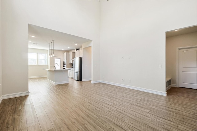 unfurnished living room featuring light hardwood / wood-style flooring and sink