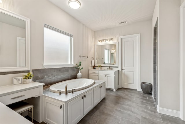 bathroom featuring vanity and a tub to relax in