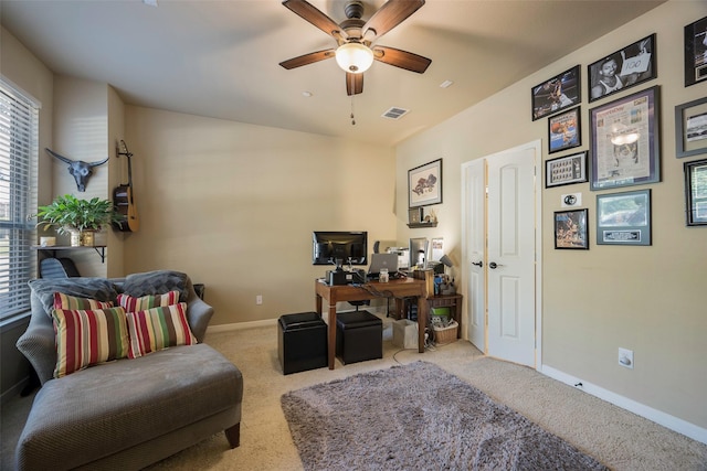 carpeted home office featuring ceiling fan