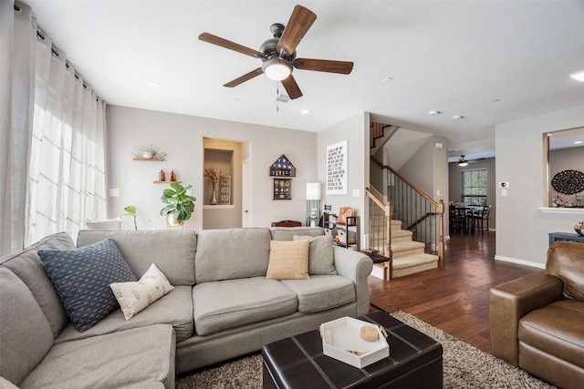 living room with dark wood-type flooring and ceiling fan