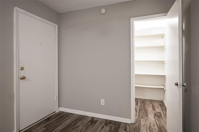 interior space with a textured ceiling and dark hardwood / wood-style flooring