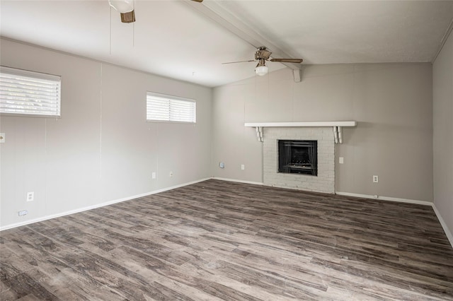 unfurnished living room with hardwood / wood-style floors, lofted ceiling with beams, a brick fireplace, and ceiling fan