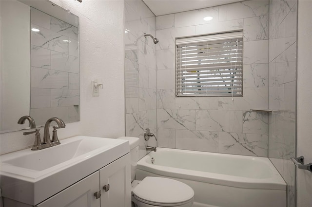 full bathroom with vanity, tiled shower / bath combo, and toilet