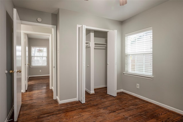 unfurnished bedroom with a closet, dark wood-type flooring, and ceiling fan