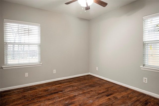 empty room featuring a wealth of natural light, ceiling fan, and dark hardwood / wood-style floors