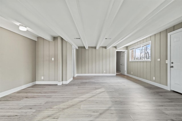 interior space featuring beamed ceiling and light hardwood / wood-style flooring