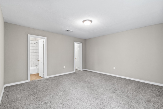 unfurnished bedroom featuring carpet flooring and connected bathroom