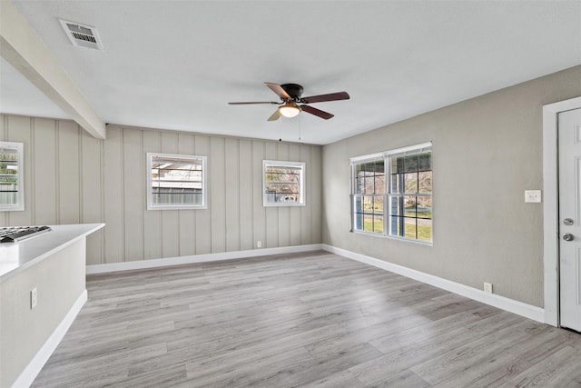 interior space featuring beamed ceiling, ceiling fan, and light wood-type flooring