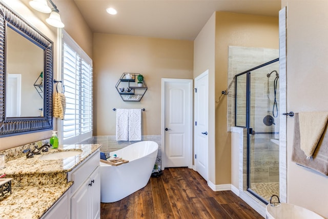 bathroom featuring vanity, hardwood / wood-style flooring, plenty of natural light, and separate shower and tub