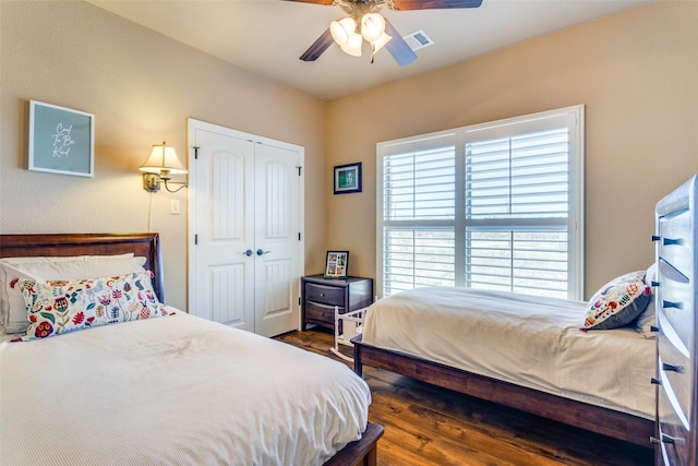 bedroom featuring ceiling fan, dark hardwood / wood-style flooring, and a closet