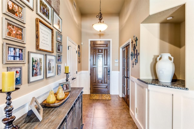 foyer featuring dark tile patterned floors