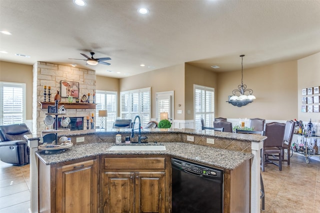 kitchen featuring dishwasher, sink, hanging light fixtures, a kitchen island with sink, and a healthy amount of sunlight