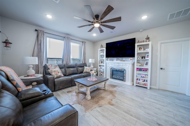 living room featuring light hardwood / wood-style flooring and ceiling fan